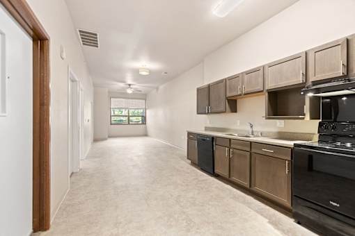 A kitchen with black appliances and wooden cabinets.