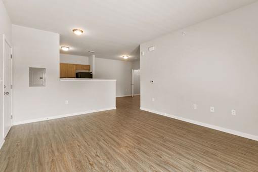 A room with wooden flooring and white walls.