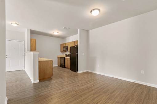 A kitchen area with wooden floors and white walls.