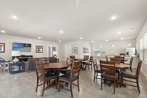 A dining room with a large table and chairs.