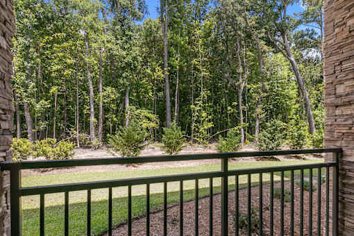 A green fence in front of a forest.