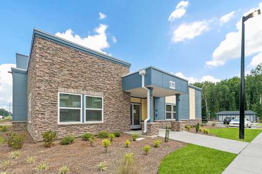 A modern house with a stone facade and a blue roof.