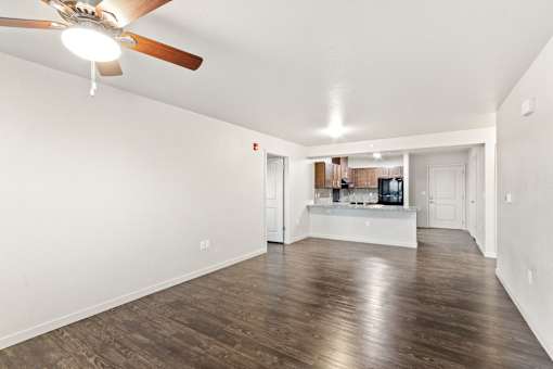 A room with a ceiling fan and wooden flooring.