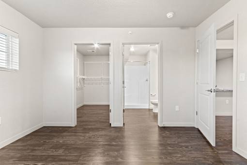 A large, empty room with wooden floors and white walls.