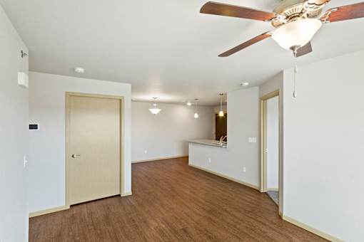A room with a ceiling fan and wooden floors.