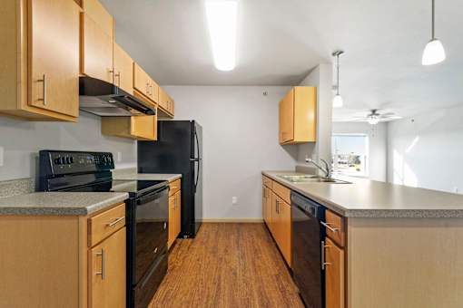 A kitchen with wooden cabinets and black appliances.