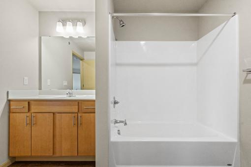 A white bathroom with a sink and a bathtub.