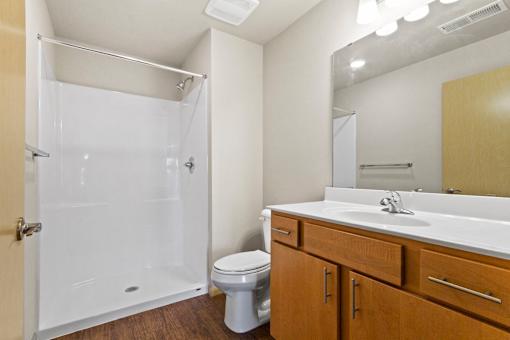 A white bathroom with a toilet, sink, and shower.