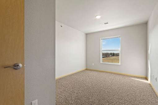 A room with a carpeted floor and a picture hanging on the wall.
