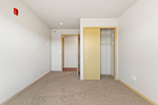 A room with two doors and a carpeted floor.