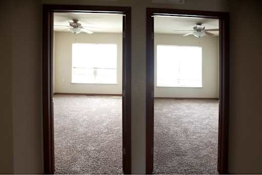 Two rooms with carpet floors and ceiling fans.