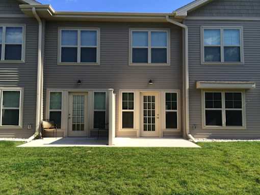 A grey house with a white door and windows.