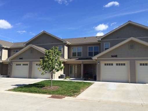A tree is in front of a house with the numbers 1446 and 1448 on the front of the house.