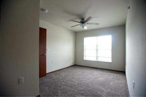 A room with a ceiling fan and a window.