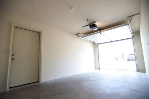 A room with a white door and a window with a light on the ceiling.
