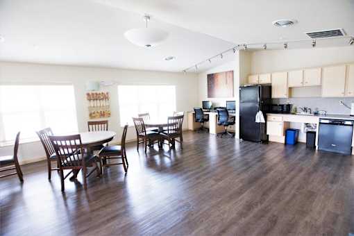 A kitchen with a refrigerator, sink, and cabinets.