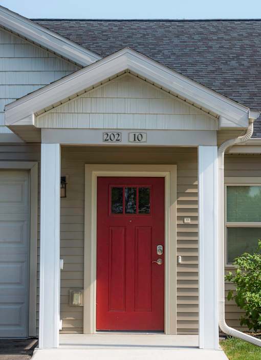 A house with a red door and the number 20210 on the wall above it.