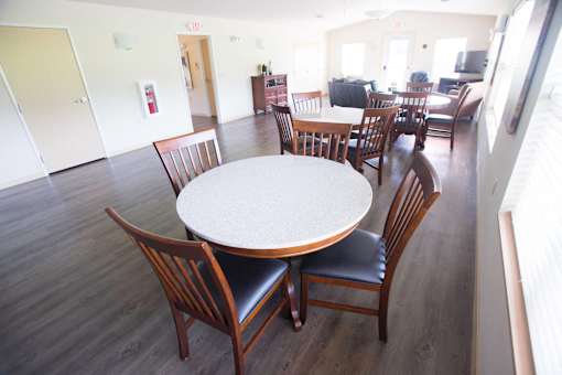 A round table with chairs around it in a room.