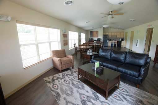 A living room with a black leather couch and a coffee table.