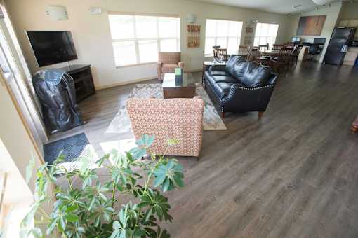 A living room with a couch, chairs, and a television.