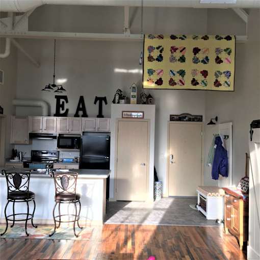 A kitchen with a white counter and a black fridge.