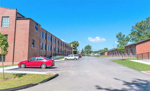 A red car is parked on the side of a street.