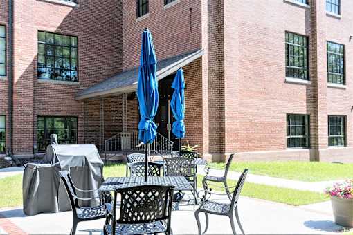A patio with a table and chairs with umbrellas.