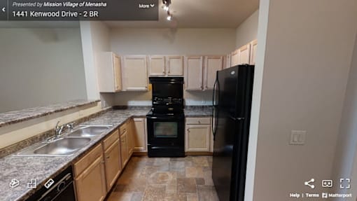 A kitchen with a black refrigerator and a black oven.