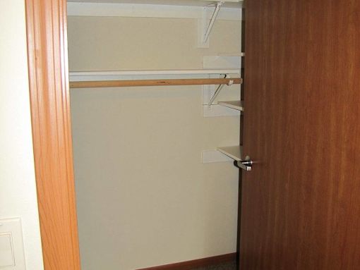 A brown door with a white handle and a shelf.