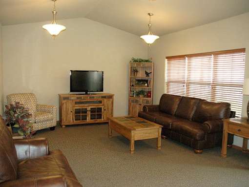 A living room with a brown leather couch and a wooden coffee table.