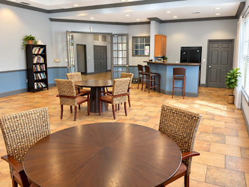 A dining room with a large table surrounded by chairs.