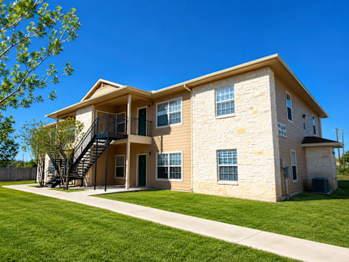 A two-story house with a balcony on the second floor.