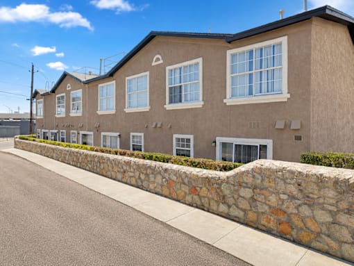 A row of houses with stone walls on the side.
