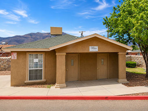 A small building with a brown roof and a sign that says "Office" on it.