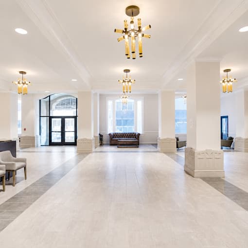A large, well-lit lobby with a chandelier and a bench.