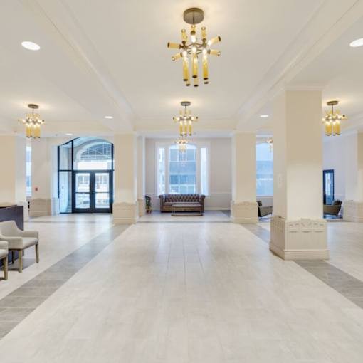 A large, well-lit lobby with a marble floor and a chandelier hanging from the ceiling.