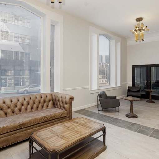 A brown tufted sofa sits in a room with a wooden coffee table in front of it.