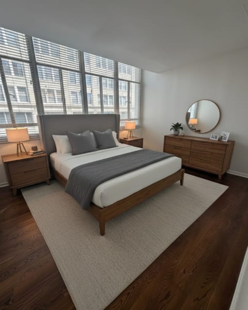 A bedroom with a large bed, a dresser, and a mirror.