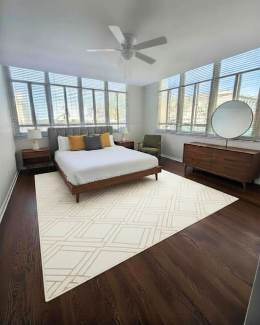 A bedroom with a bed, dresser, and mirror.