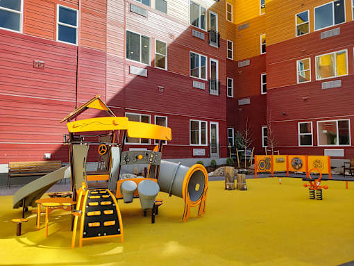 A playground with a red, yellow, green and blue arch.