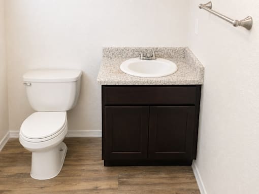 A white toilet sits next to a sink in a bathroom.