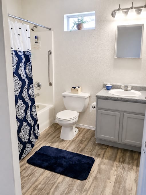 A bathroom with a toilet, sink, and shower curtain.
