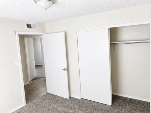 A white closet with two doors and a shelf.