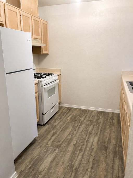 A kitchen with a white refrigerator and a white stove top oven.