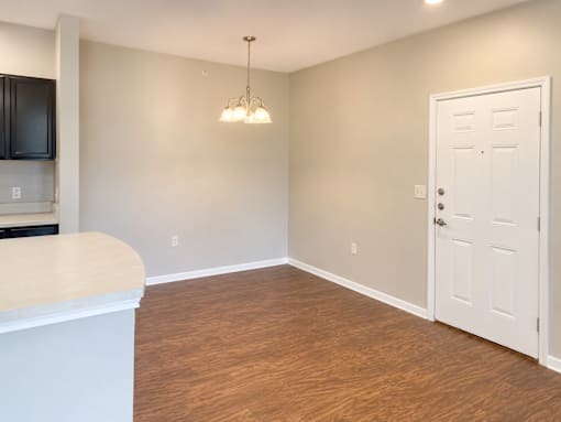 A room with a white door and a wooden floor.