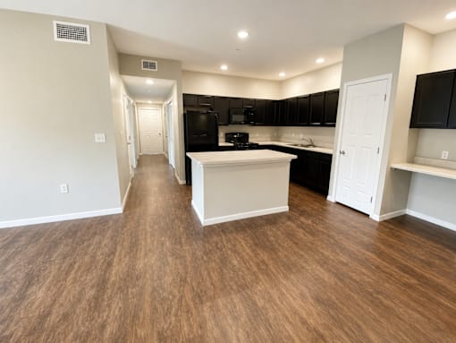A kitchen with black cabinets and a white island.