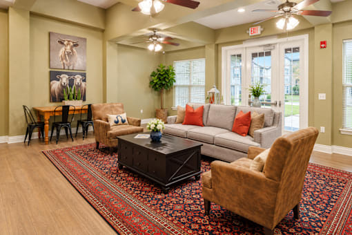 A living room with a couch, chairs, and a rug.