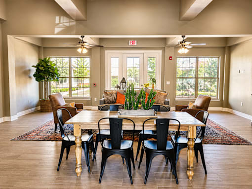 A dining room with a large table and chairs.