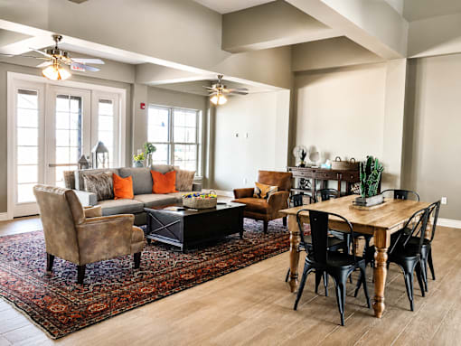 A living room with a brown rug and a wooden table.