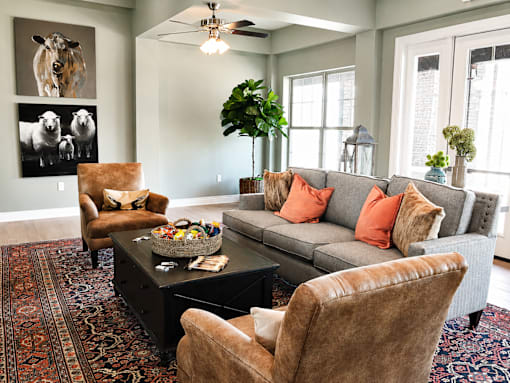 A living room with a grey couch, brown leather chairs, and a coffee table.